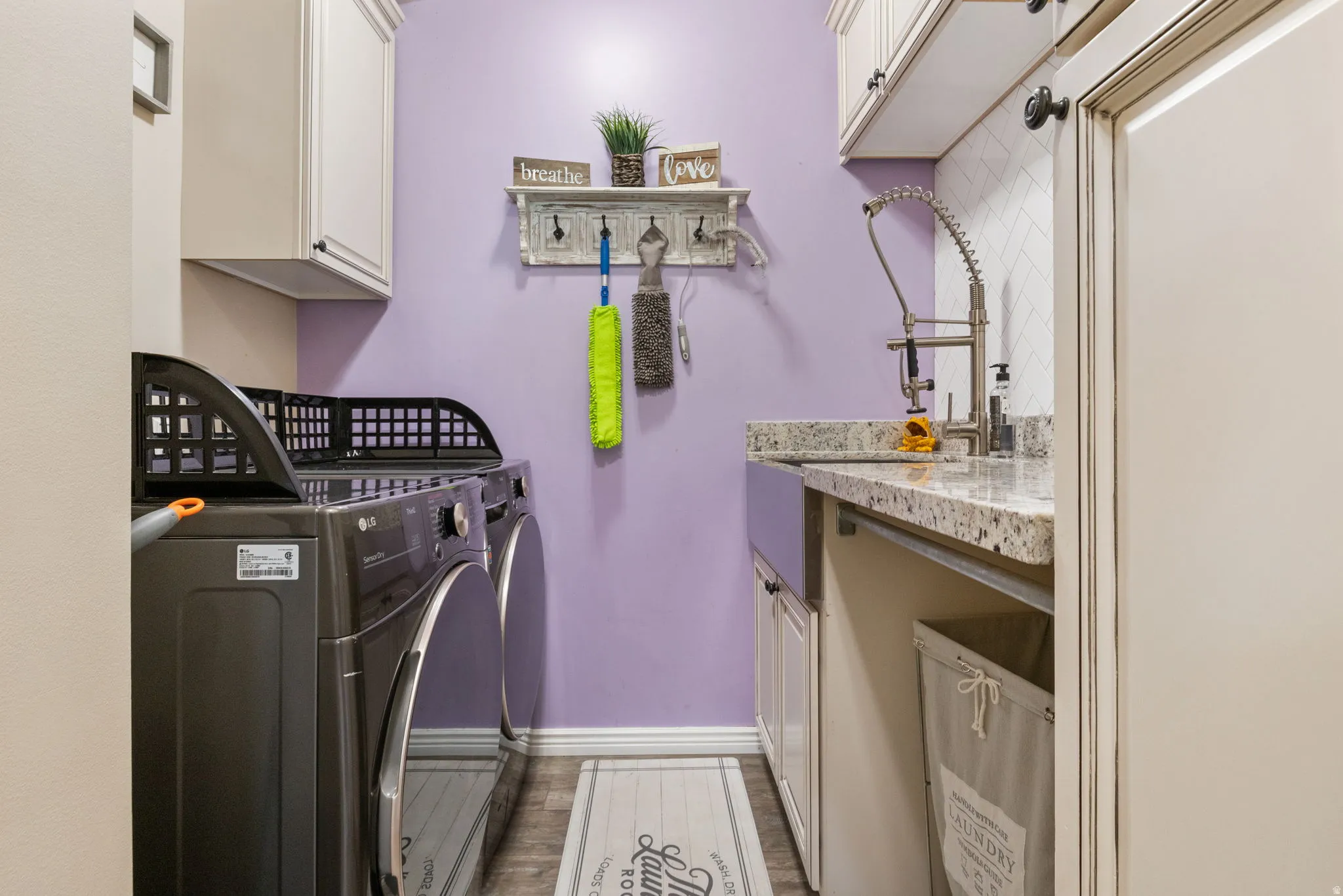 Washroom with cabinet space, independent washer and dryer, and wood finished floors