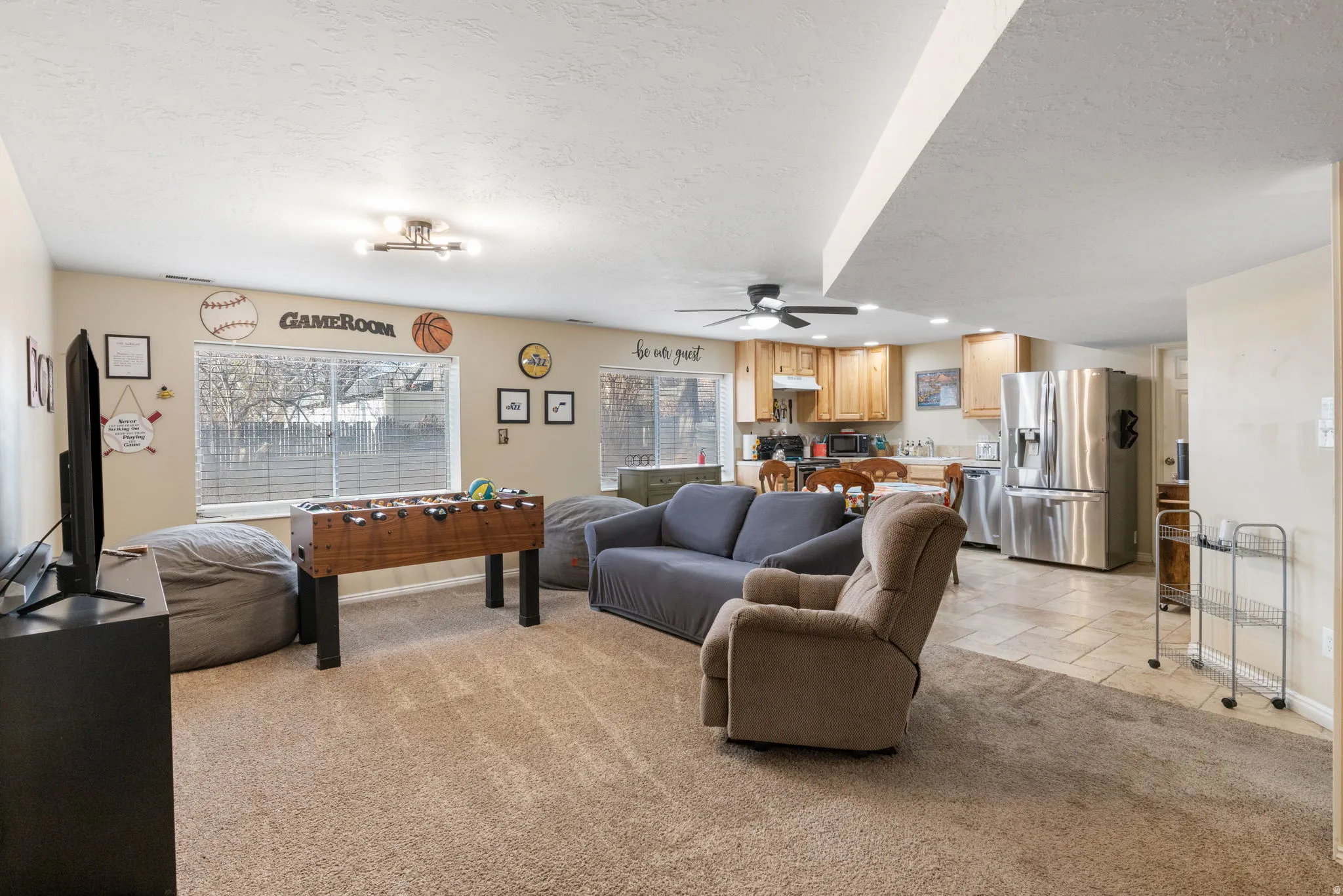 Living area featuring healthy amount of natural light, light carpet, recessed lighting, a textured ceiling, and a ceiling fan