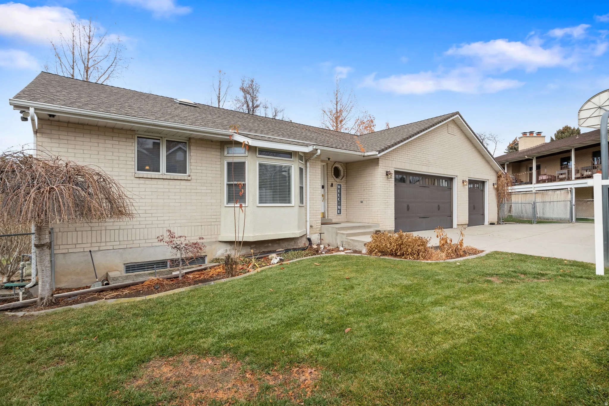 View of front of home featuring concrete driveway, a garage, roof with shingles, and brick siding