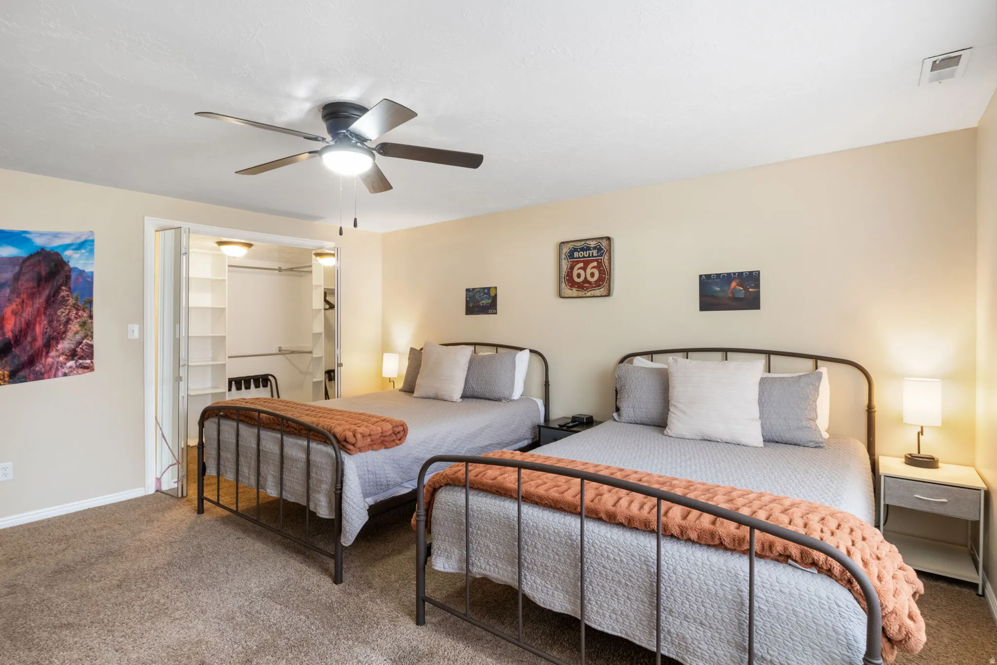 Carpeted bedroom featuring a spacious closet and a ceiling fan