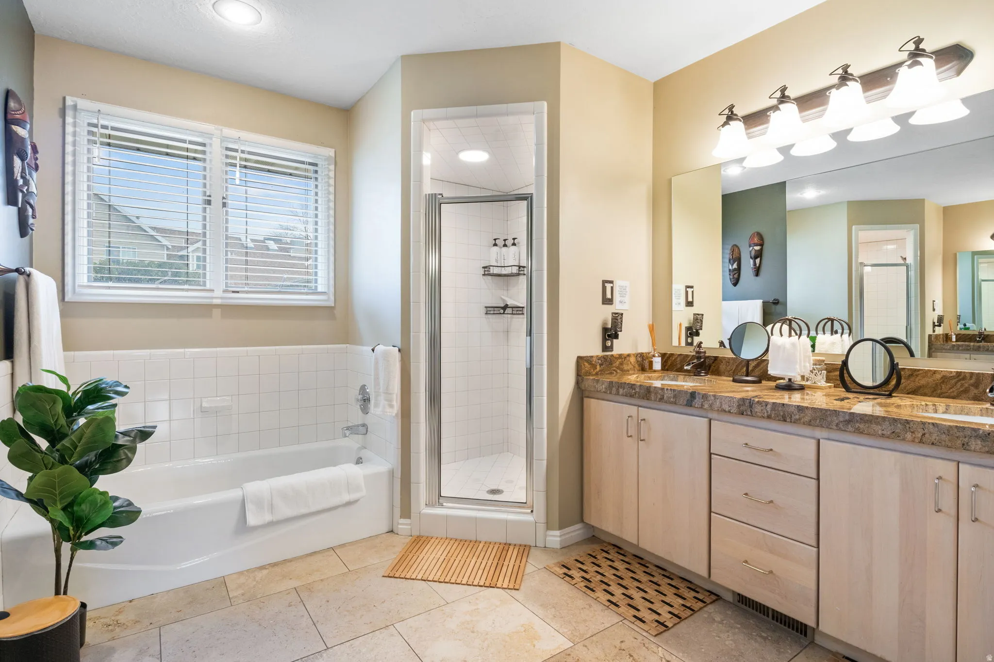 Full bath with a shower stall, a bath, double vanity, and light tile patterned flooring