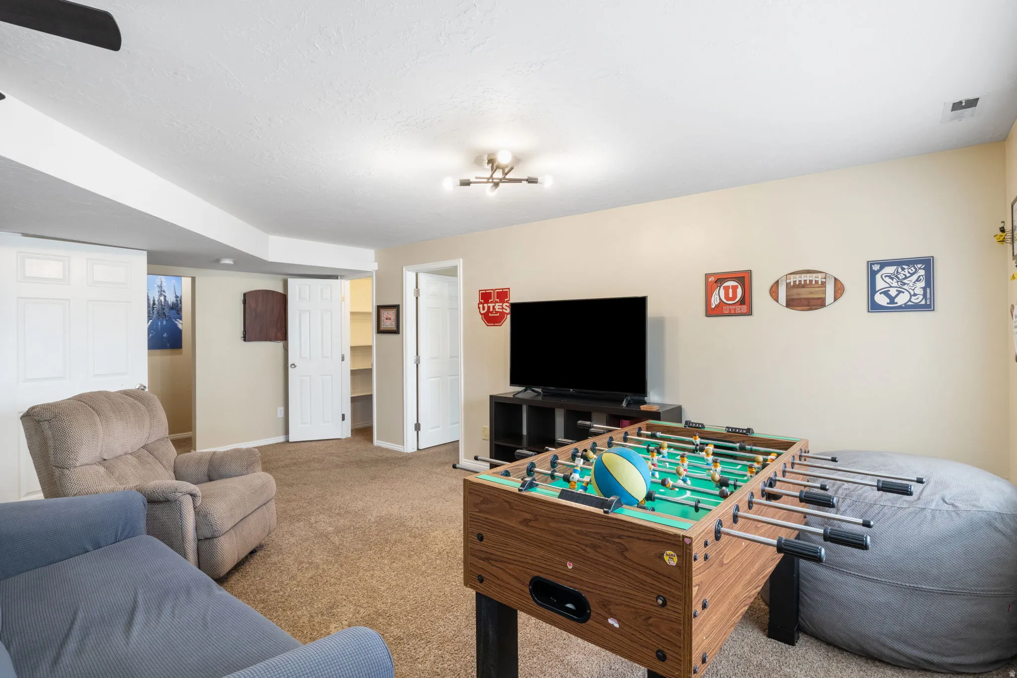 Recreation room featuring carpet floors and a textured ceiling