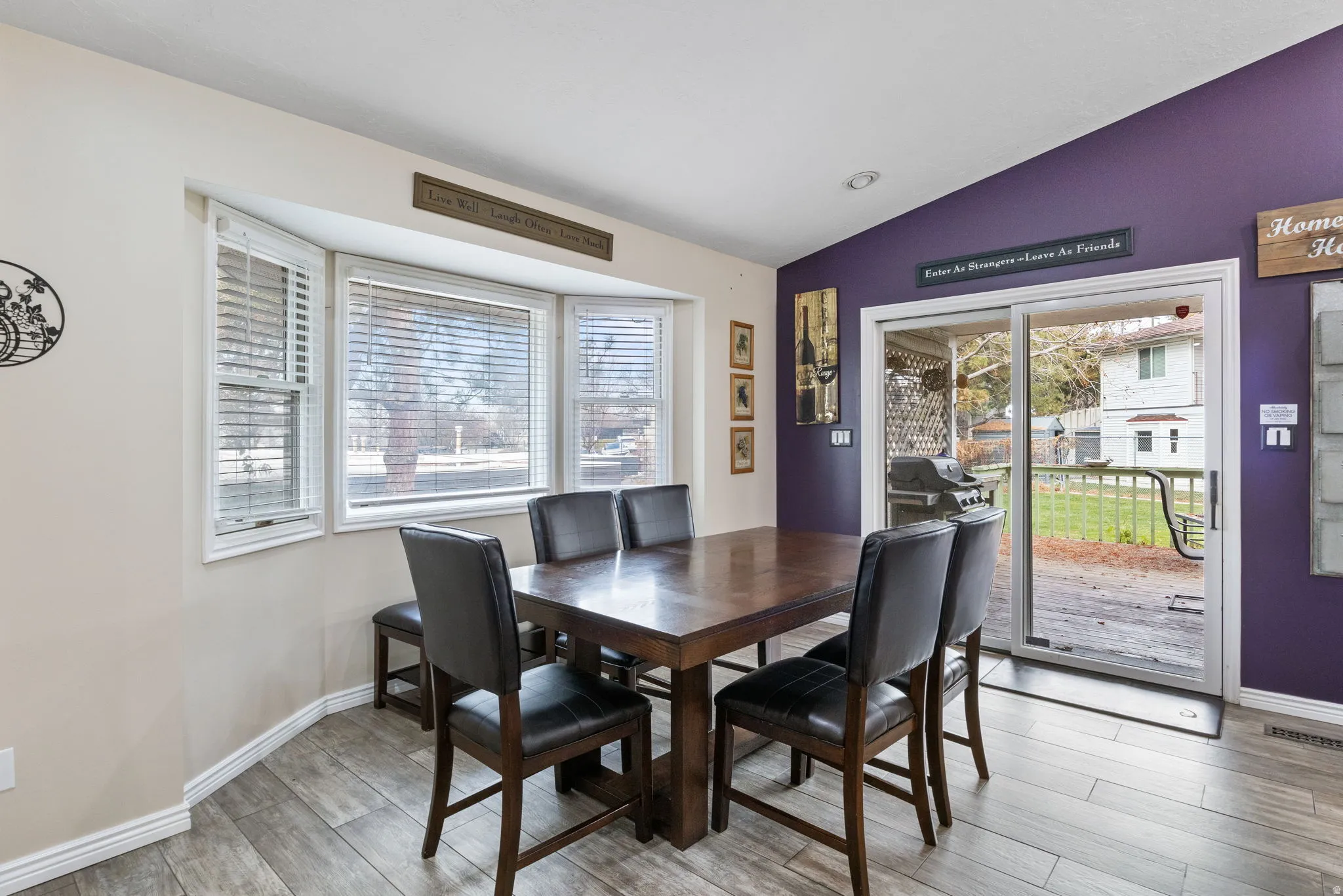 Dining space with lofted ceiling, light wood-style floors, and healthy amount of natural light