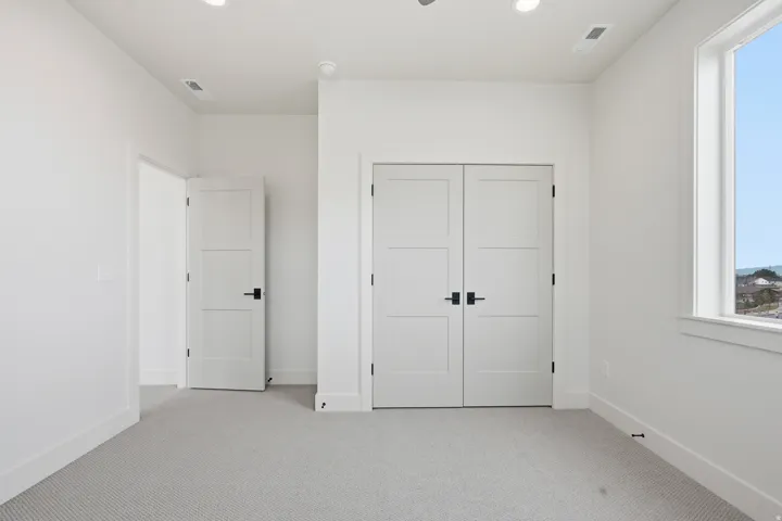 Unfurnished bedroom with carpet, a closet, and recessed lighting