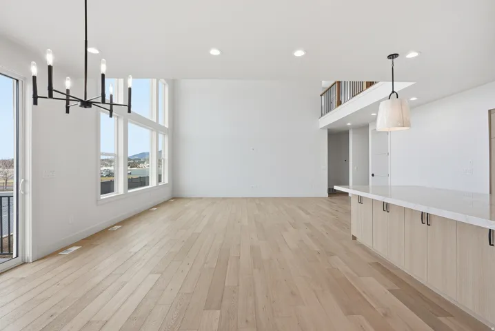 Unfurnished dining area with light wood-style flooring, suspended lighting, and a mountain view