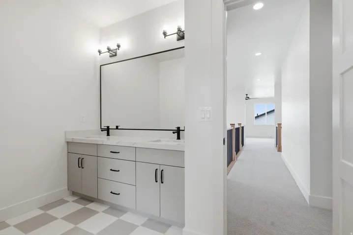Bathroom featuring double vanity, light flooring, and recessed lighting