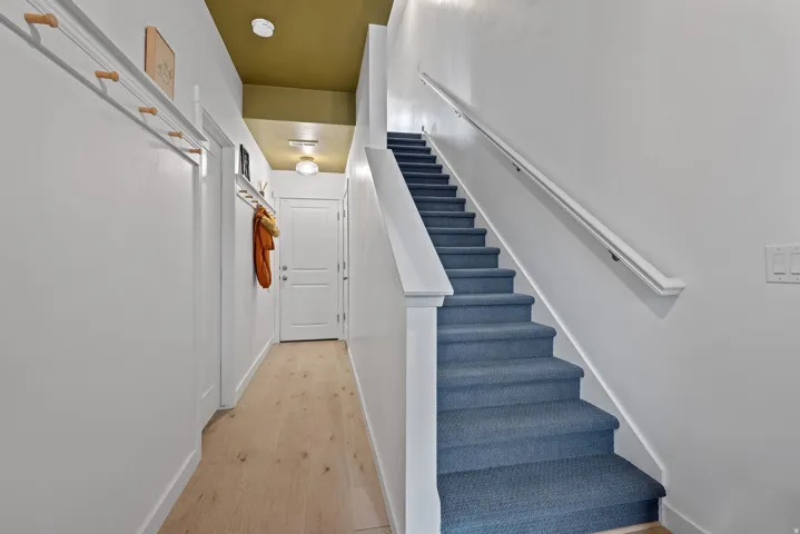 Hardwood floors, and baseboards throughout the house, dark gray carpet on stairs.
