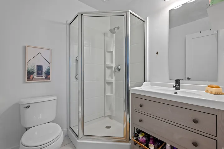 Bathroom with vanity, a stall shower, and tile patterned floors