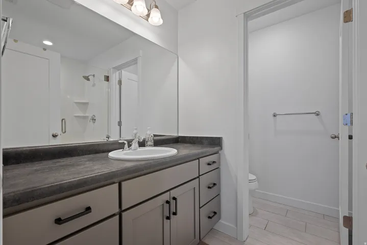 Bathroom featuring vanity, a stall shower, and tile floors