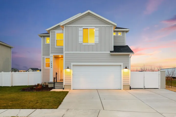 View of front of house with board and batten siding, a garage, and driveway