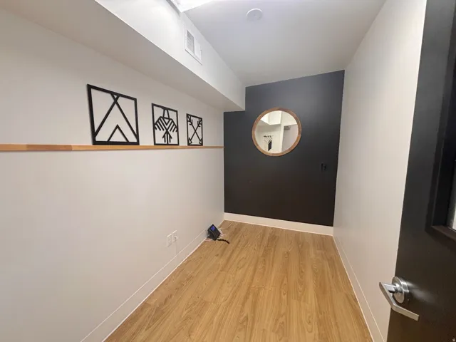 Corridor featuring light wood-type flooring and baseboards