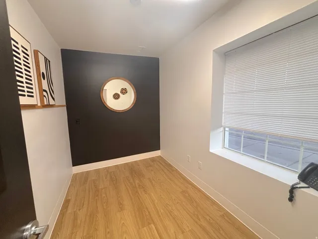 Hall with light wood-type flooring and baseboards