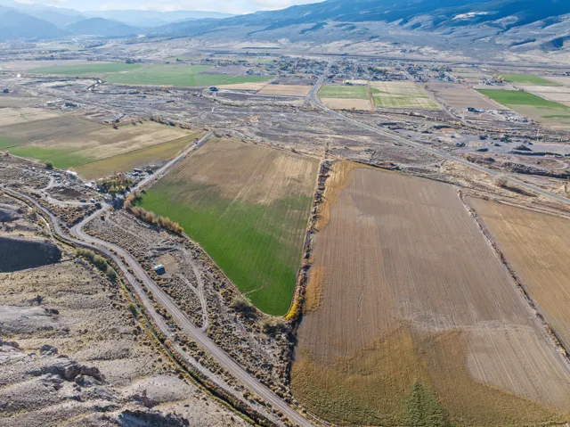 Aerial view of property's location featuring rural landscape, a mountain backdrop, and rows of crops