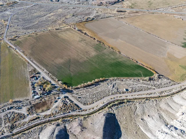Aerial view of property and surrounding area with rural landscape and rows of crops