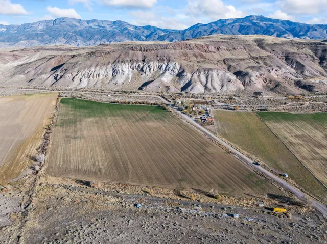 View of mountain backdrop with large plots for crops and rural landscape