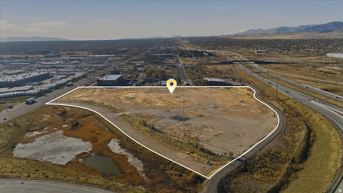 Aerial view of property and surrounding area with a mountainous background and property boundaries highlighted