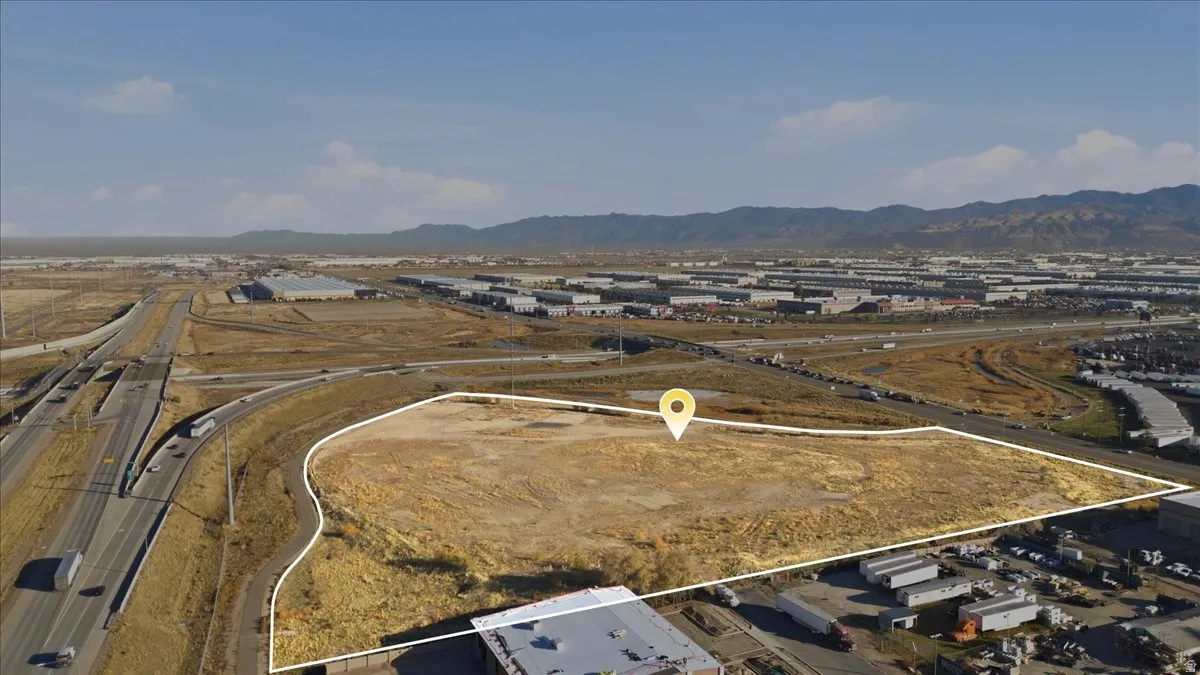 Aerial overview of property's location featuring a mountainous background and a highway