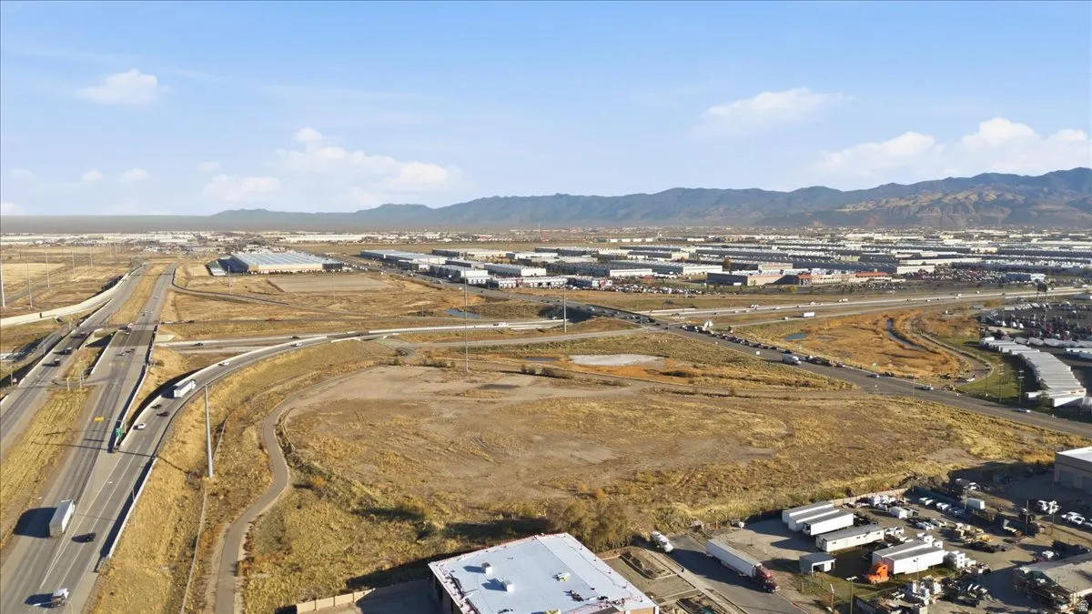 Aerial view of property and surrounding area featuring mountains and a major roadway