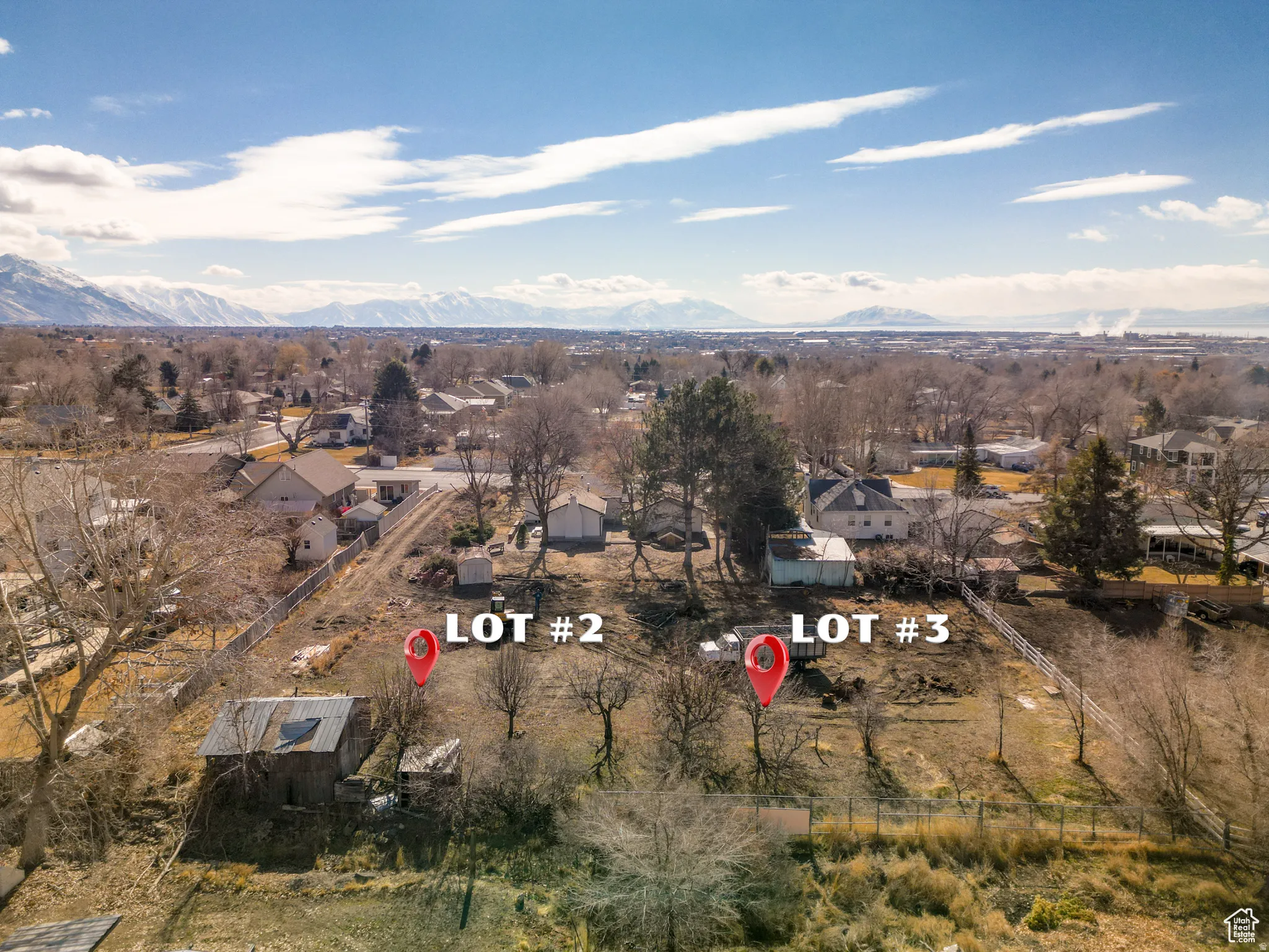Aerial view of property and surrounding area featuring nearby suburban area and a mountain backdrop
