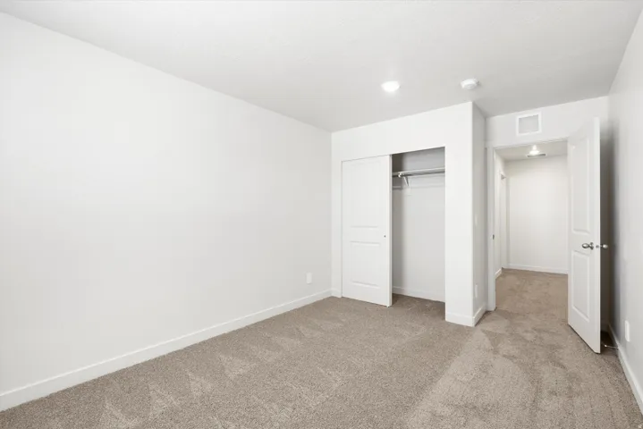 ***DISCLAIMER** Exterior & Interior finishes may vary. Unfurnished bedroom featuring light carpet and a closet