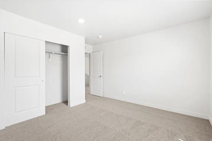 ***DISCLAIMER** Exterior & Interior finishes may vary. Unfurnished bedroom featuring light colored carpet, a closet, and recessed lighting