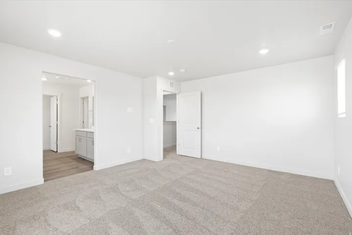 ***DISCLAIMER** Exterior & Interior finishes may vary. Unfurnished bedroom with light colored carpet, ensuite bathroom, and recessed lighting