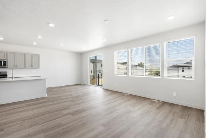 ***DISCLAIMER** Exterior & Interior finishes may vary. Unfurnished living room featuring light wood-style floors, recessed lighting, and a textured ceiling