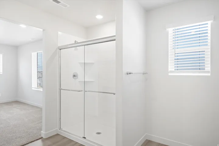 ***DISCLAIMER** Exterior & Interior finishes may vary. Bathroom with a shower stall and light wood-style flooring