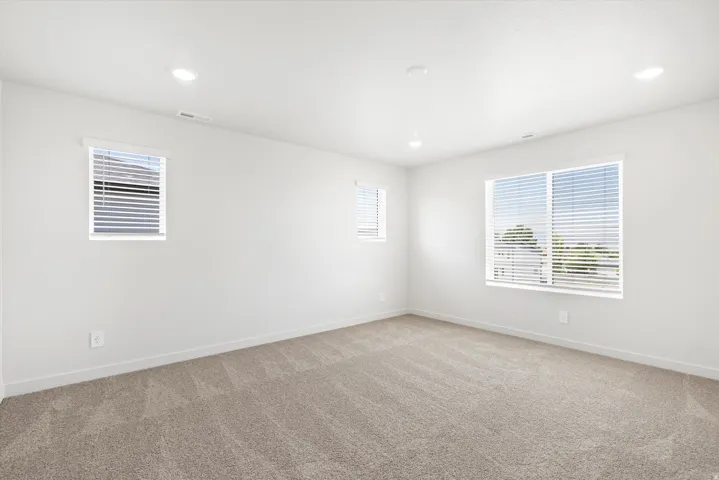 ***DISCLAIMER** Exterior & Interior finishes may vary. Empty room with plenty of natural light, carpet floors, and recessed lighting