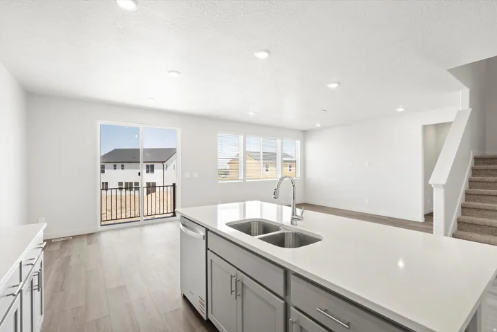 ***DISCLAIMER** Exterior & Interior finishes may vary. Kitchen with gray cabinetry, light wood-type flooring, a kitchen island with sink, dishwasher, and recessed lighting