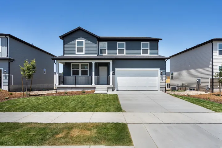 ***DISCLAIMER** Exterior & Interior finishes may vary. Traditional-style house featuring a porch, a front lawn, driveway, an attached garage, and roof with shingles