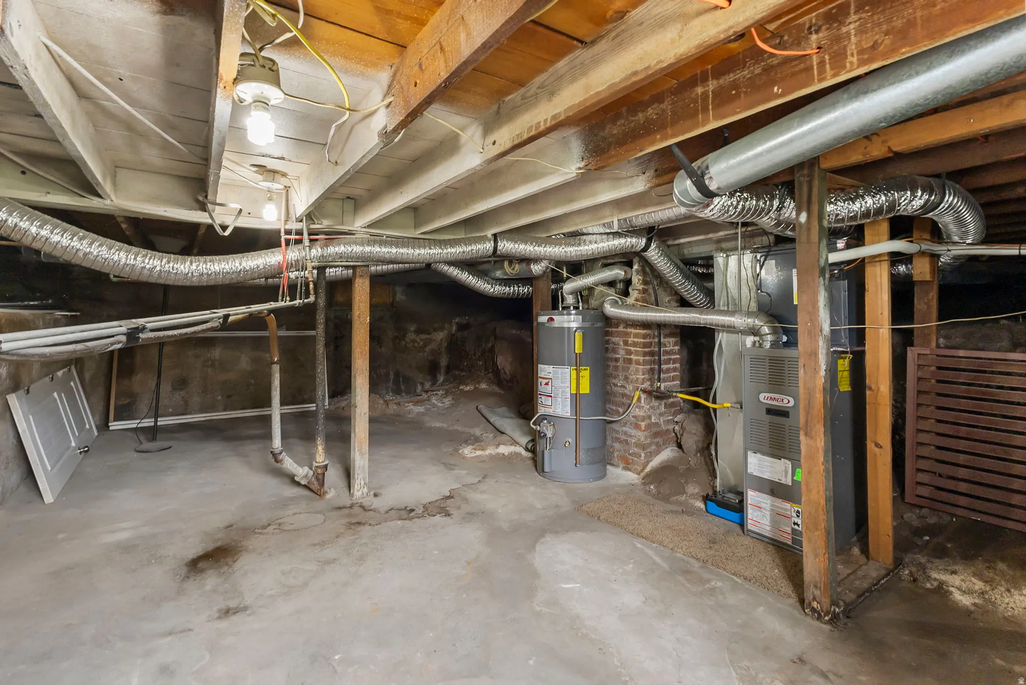 Unfinished below grade area featuring gas water heater and heating unit