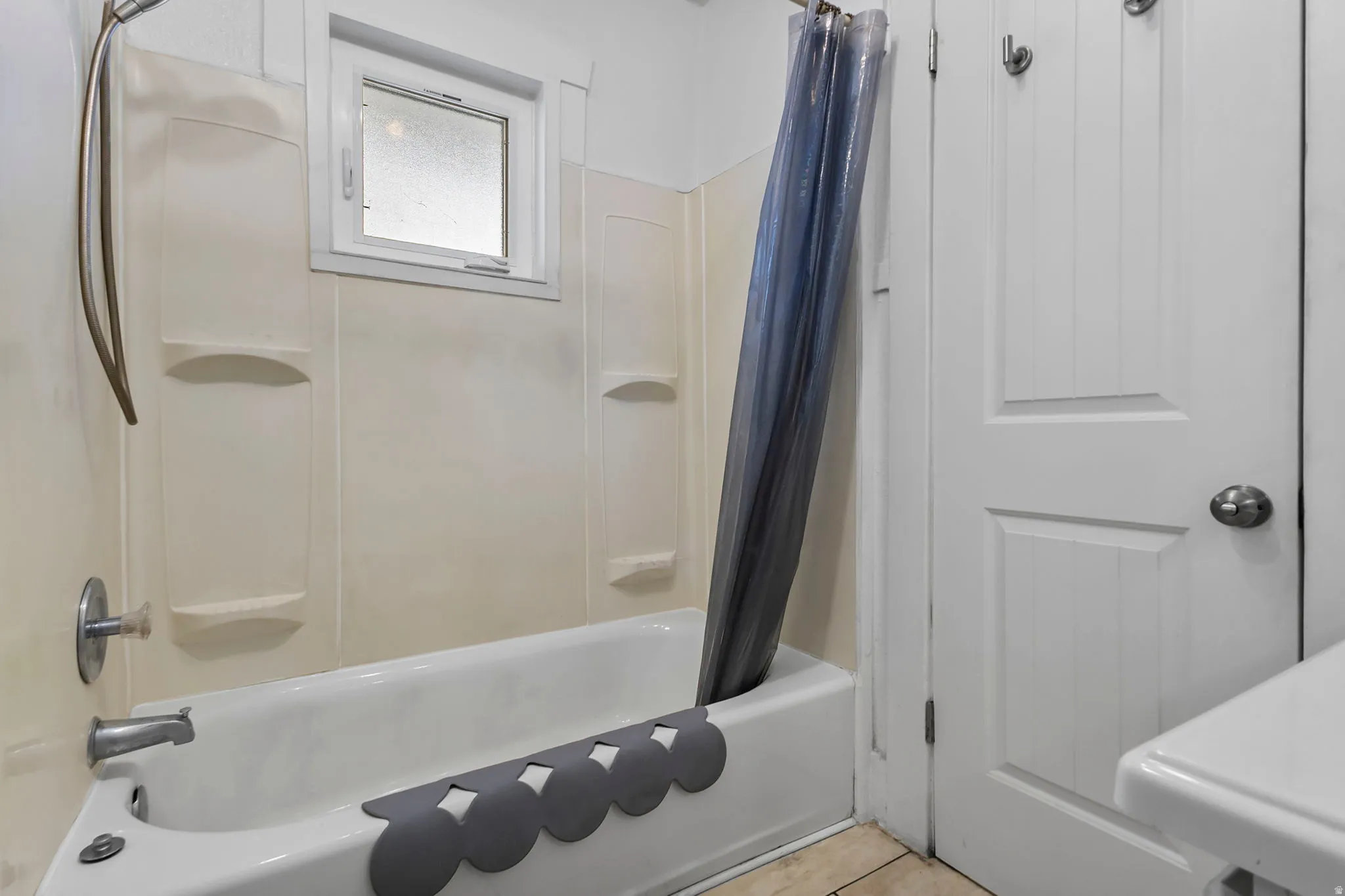 Bathroom featuring shower / bath combo and light tile patterned floors