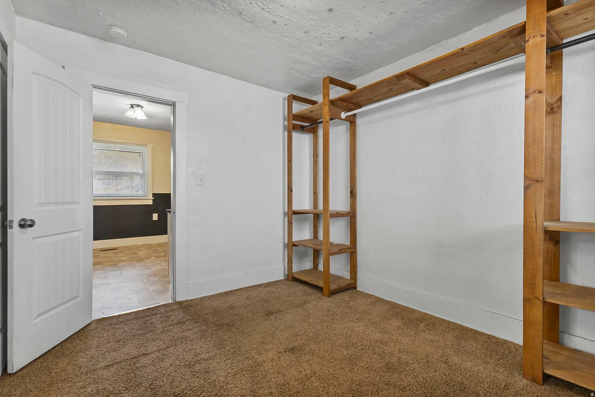 Unfurnished bedroom featuring carpet flooring and a textured ceiling