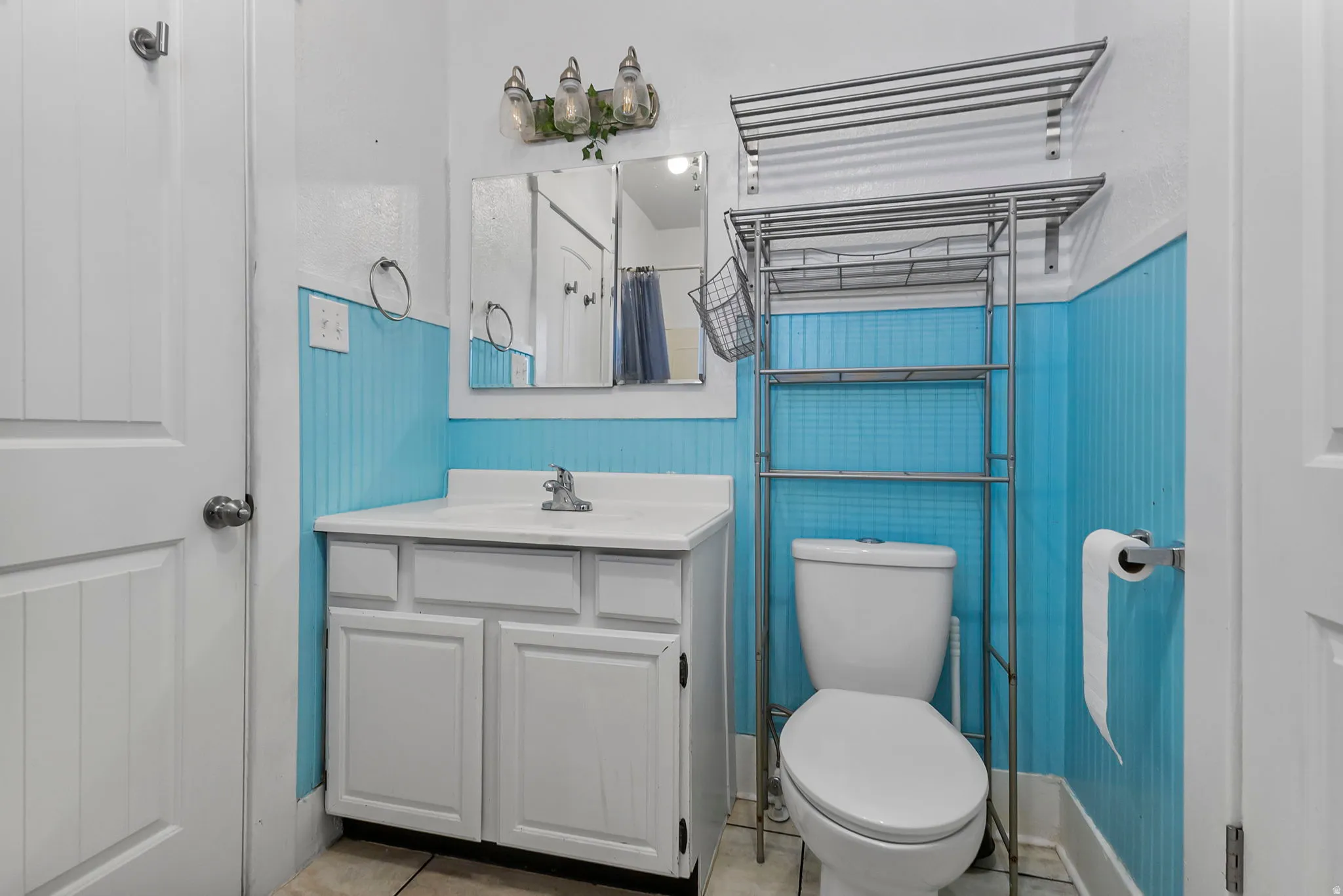 Bathroom with a shower with curtain, vanity, and light tile patterned floors