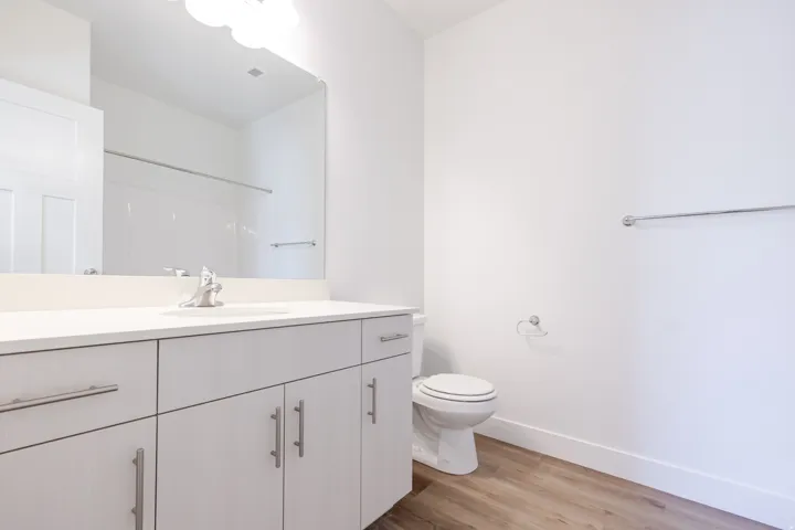 Modern bathroom featuring a vanity with an integrated sink, polished chrome faucet, and ample storage cabinetry