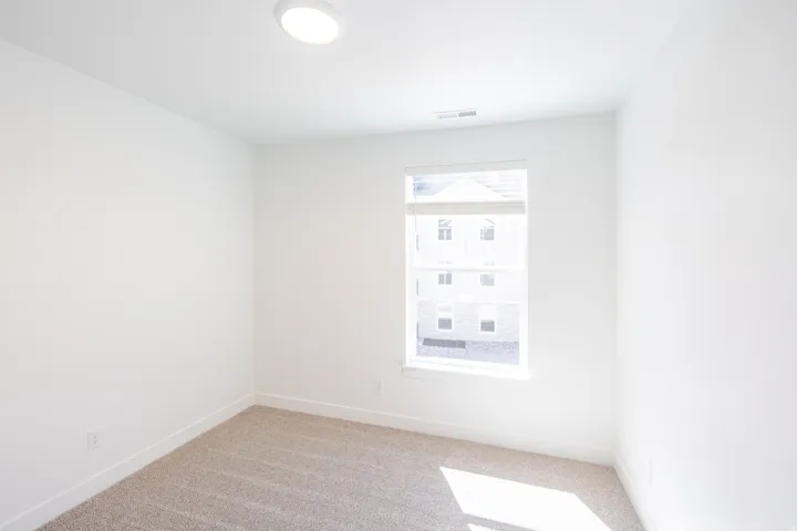 Bright interior space featuring a single window with blinds