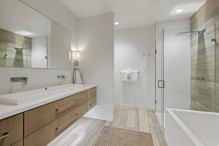 Full bath with vanity, a shower stall, a freestanding tub, and light wood-style flooring