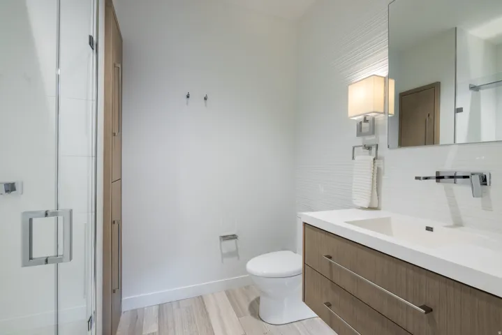Bathroom with vanity, light wood finished floors, and a shower with door