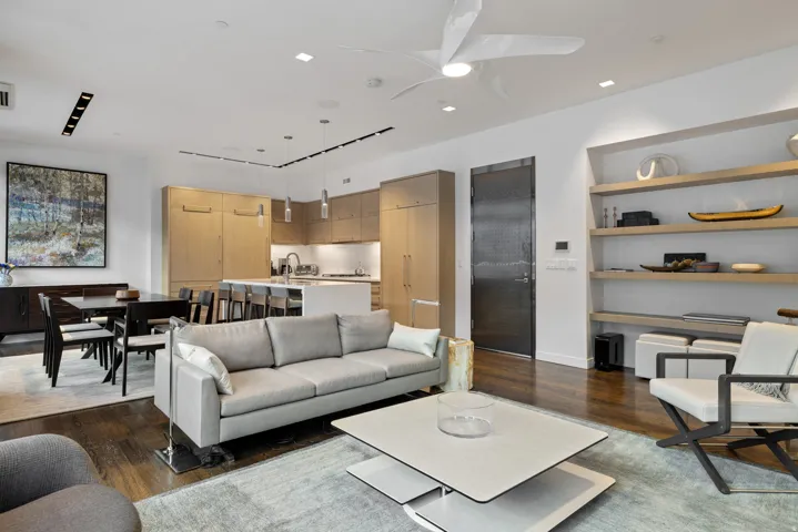 Living area featuring dark wood-type flooring and a ceiling fan