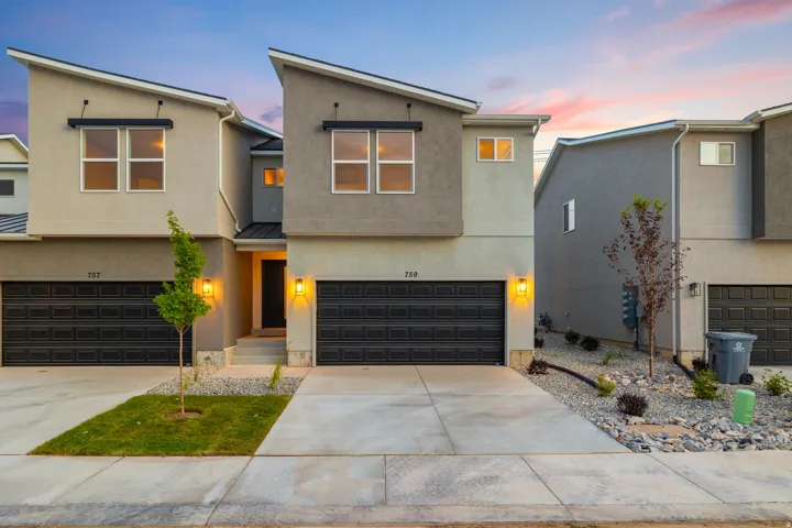 Contemporary home with stucco siding, concrete driveway, an attached garage, a metal roof, and a standing seam roof