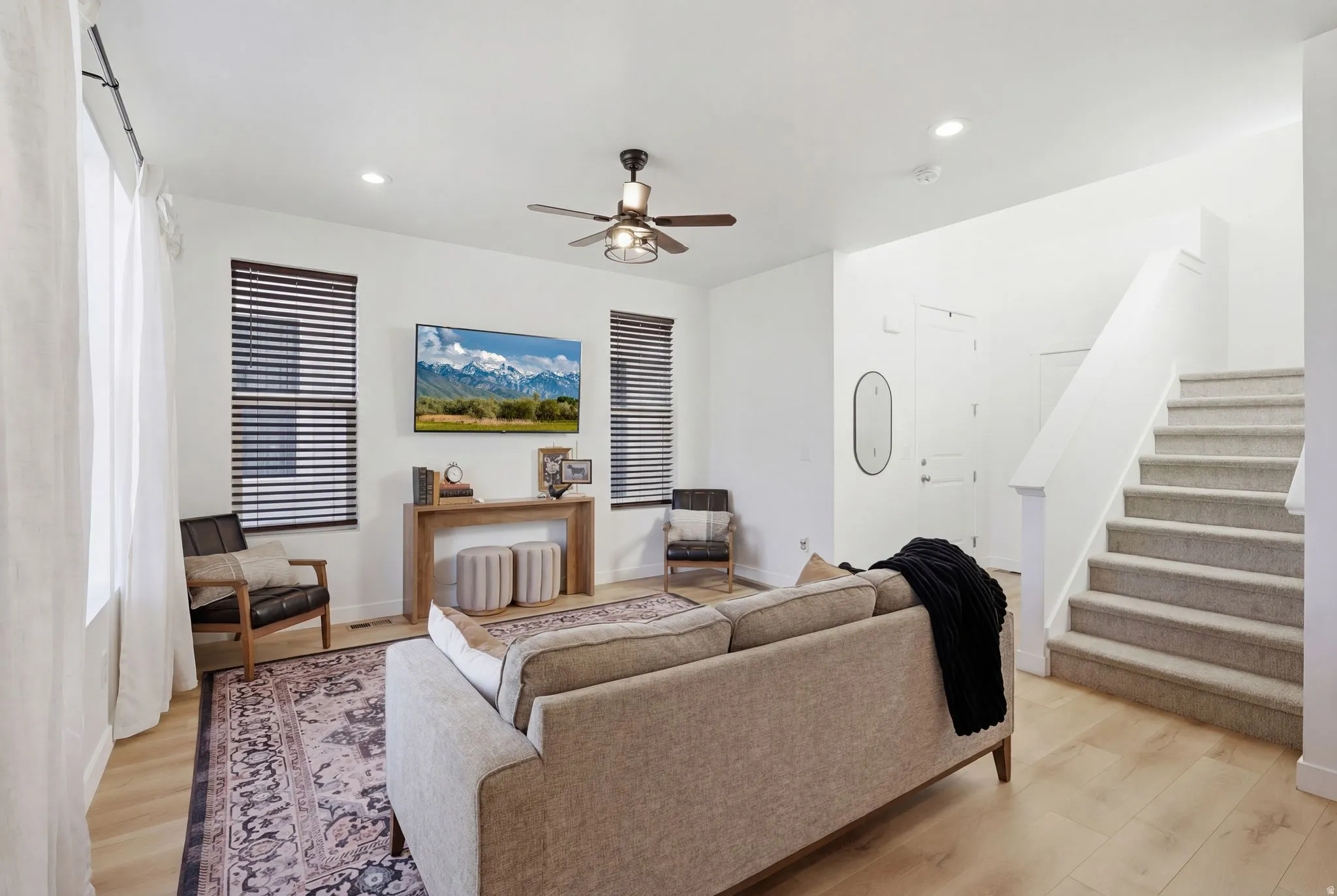 Living area with light wood finished floors, recessed lighting, and a ceiling fan