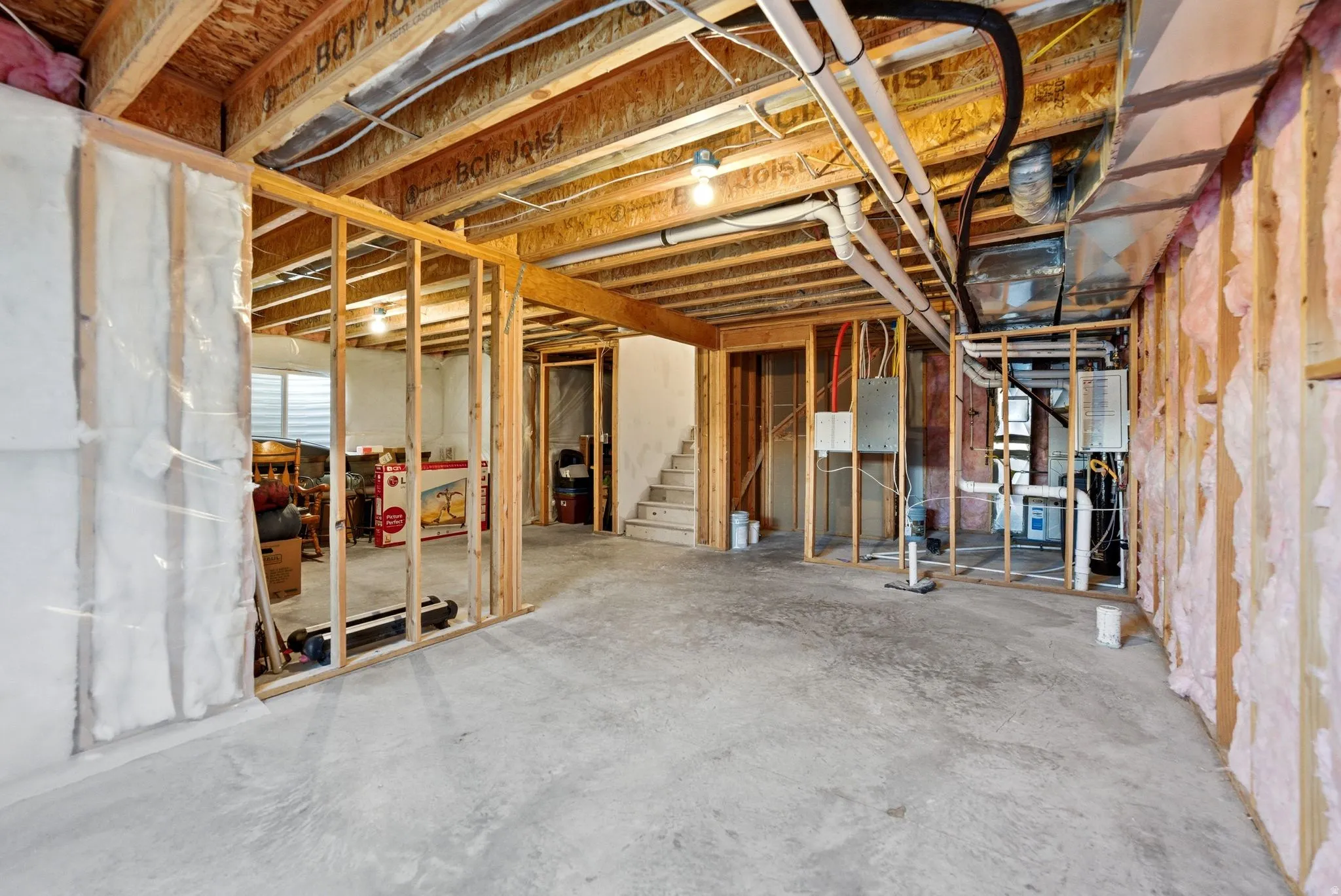Unfinished below grade area featuring stairway and electric panel