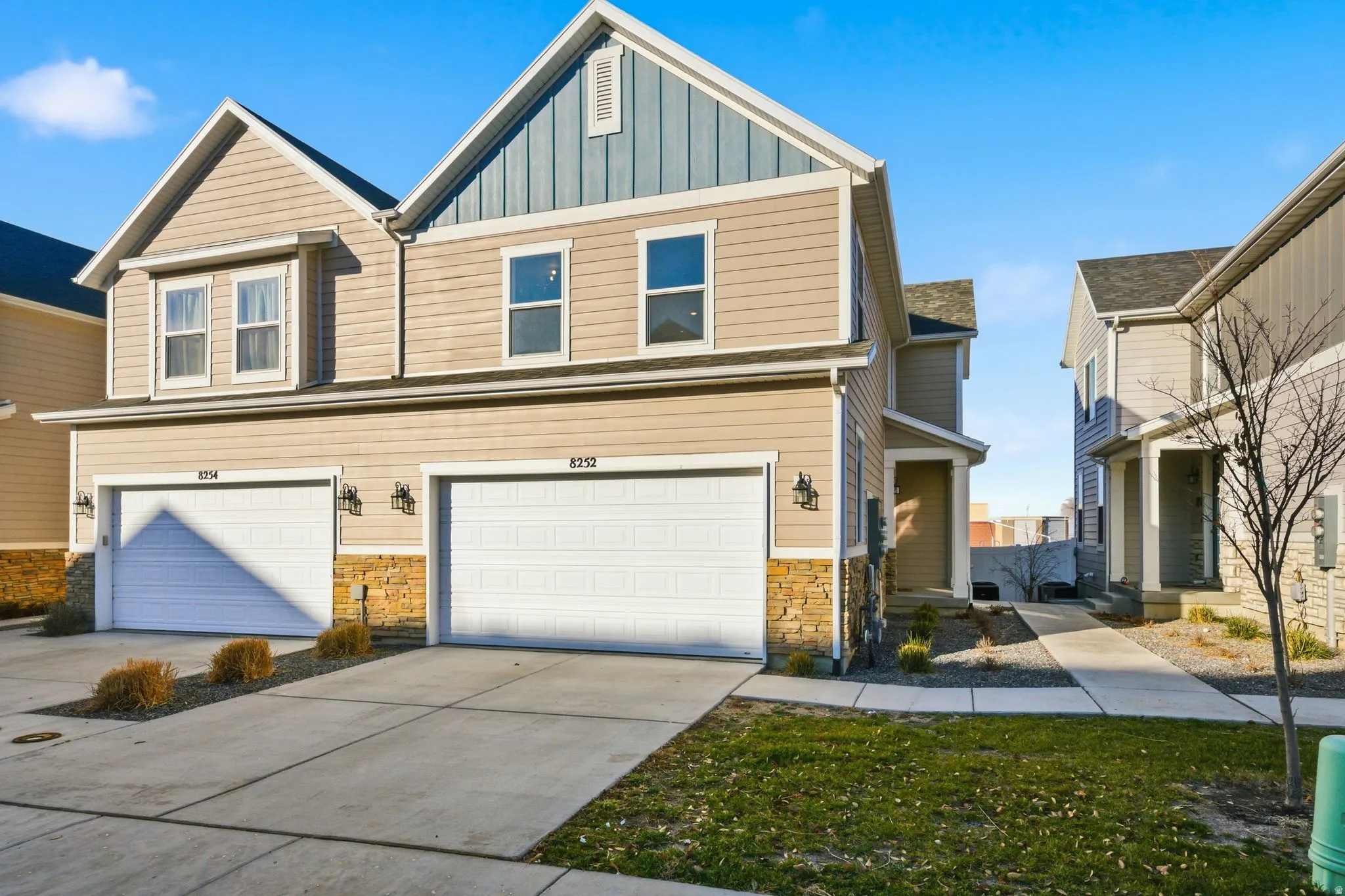 Craftsman inspired home with driveway, board and batten siding, stone siding, and an attached garage