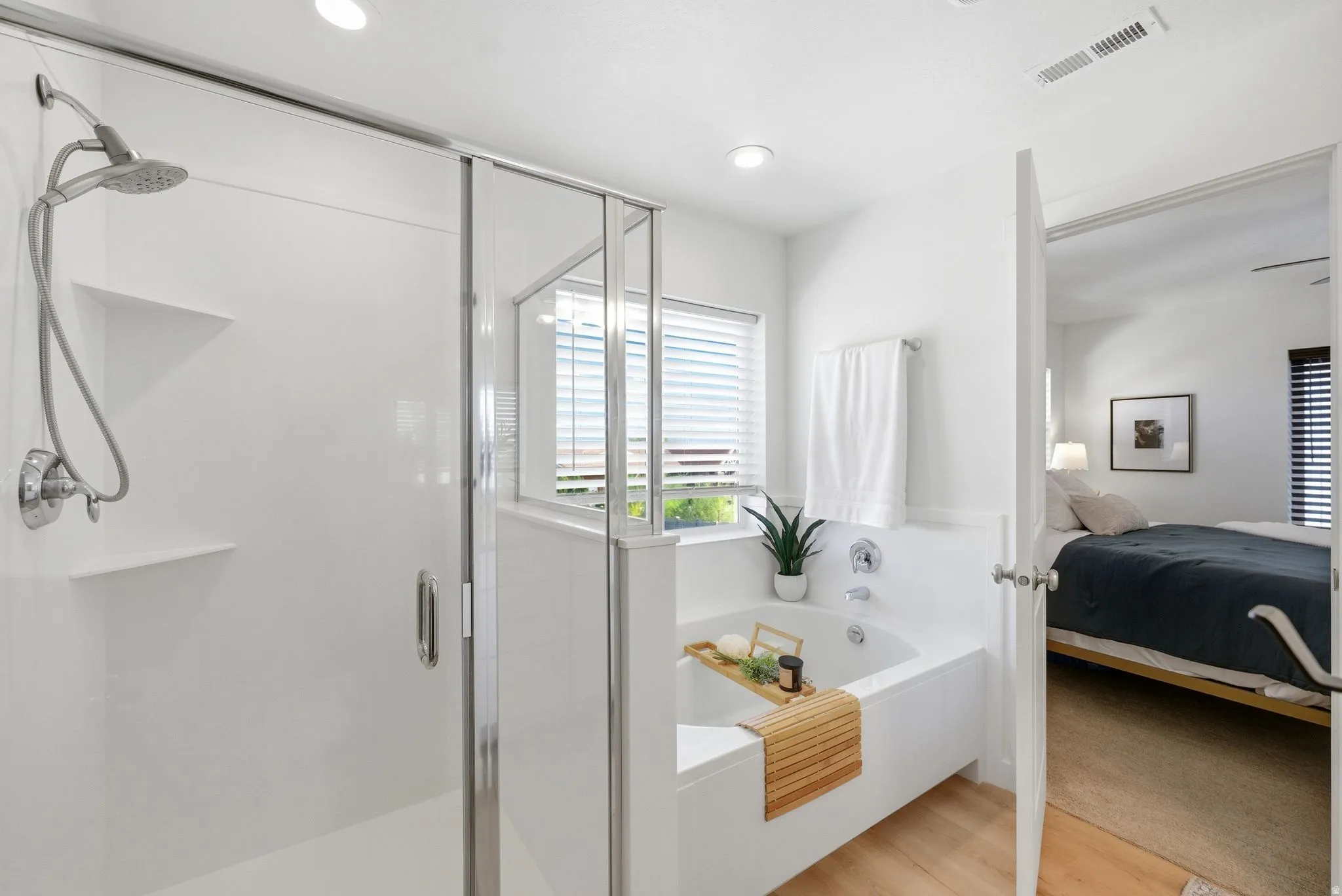 Ensuite bathroom featuring a shower stall, a bath, light wood-type flooring, and recessed lighting