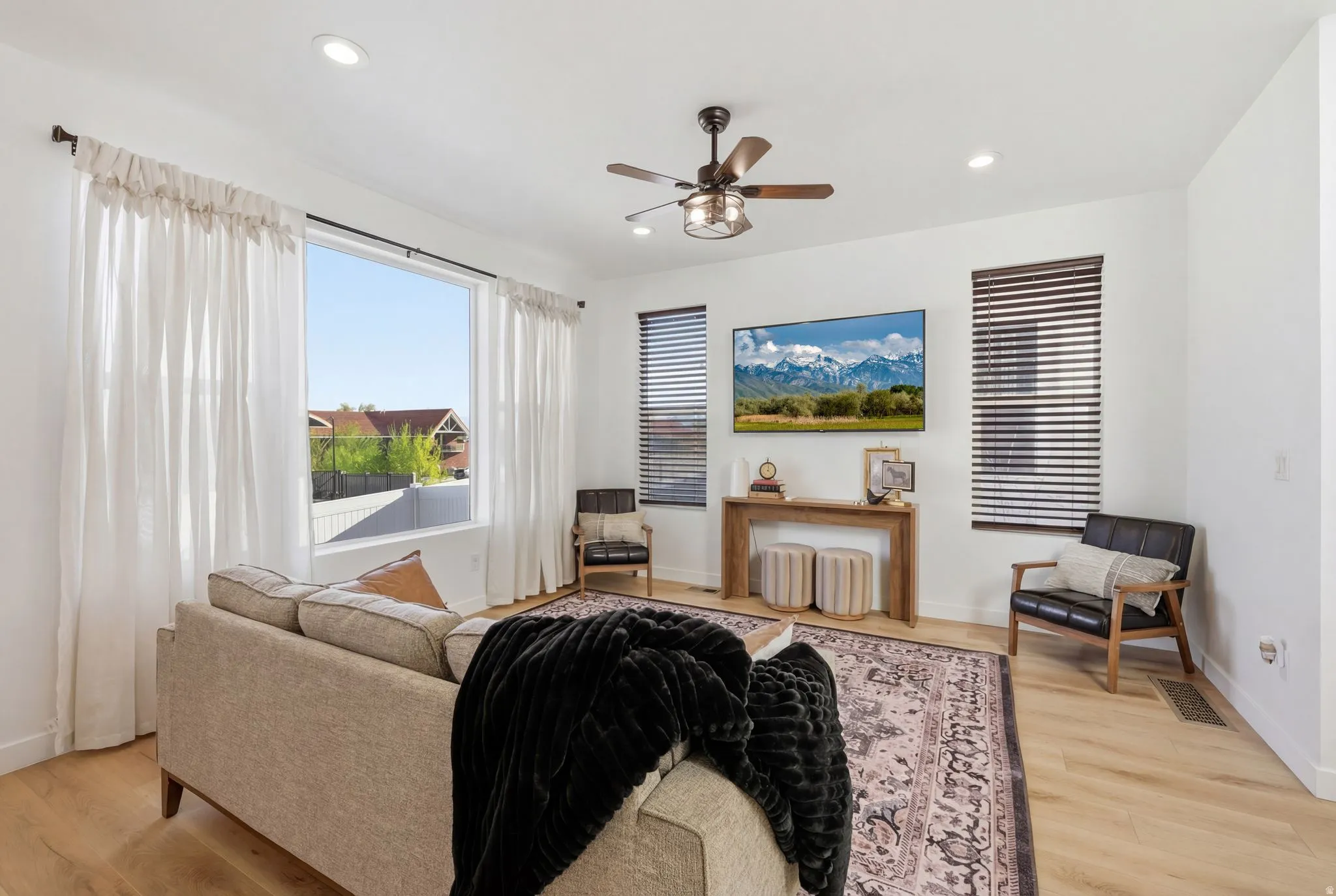 Living area with light wood-type flooring, ceiling fan, and recessed lighting