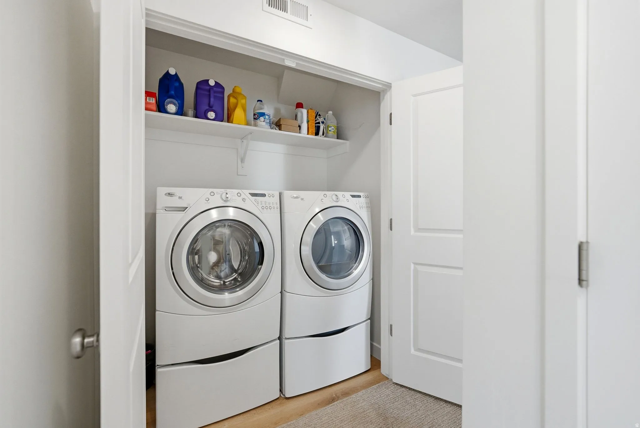Laundry room with separate washer and dryer and light wood finished floors