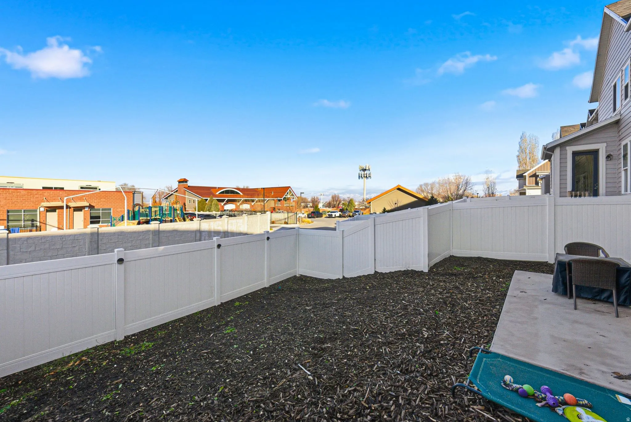 Fenced backyard with a residential view and a patio area