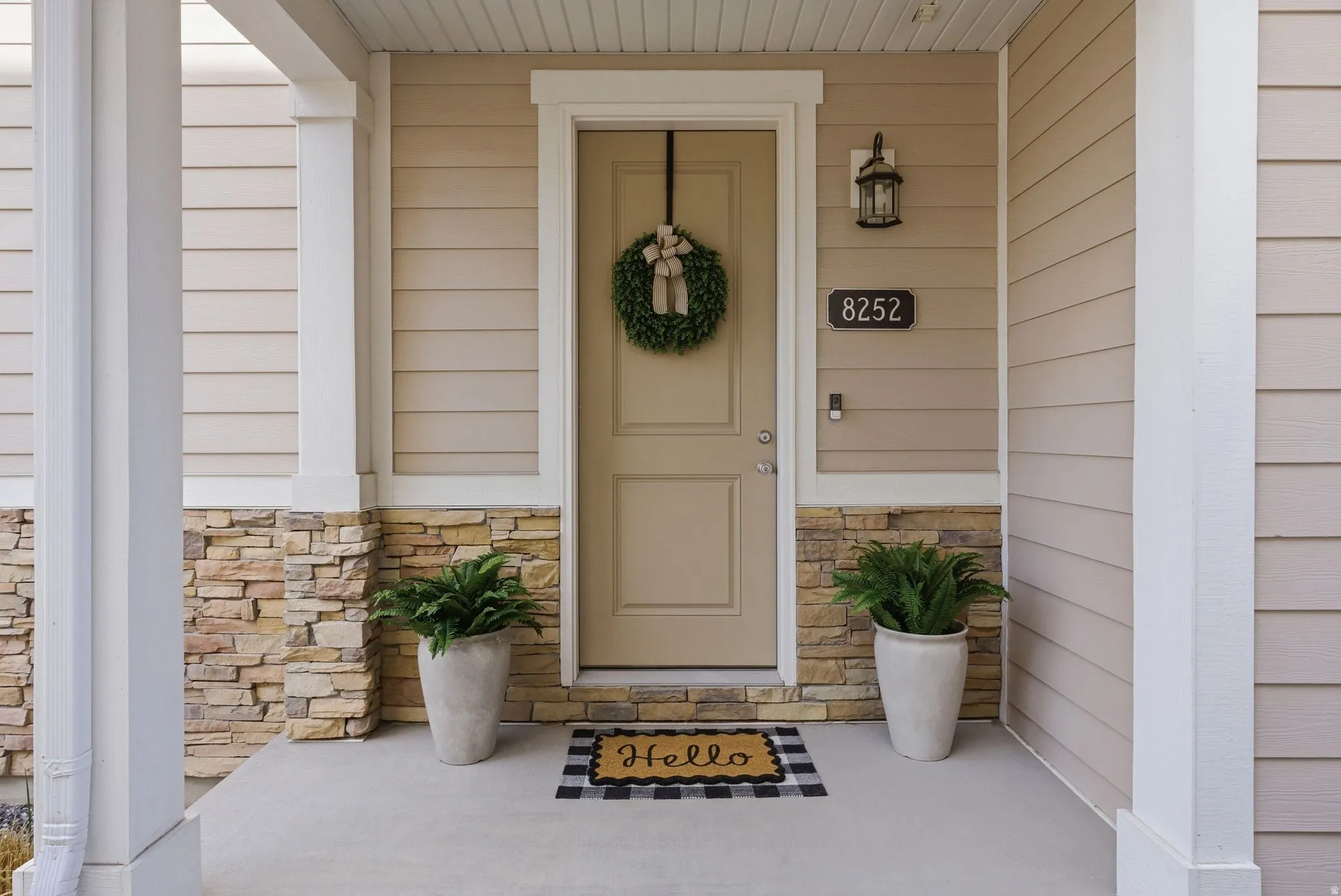 Doorway to property featuring stone siding and a porch