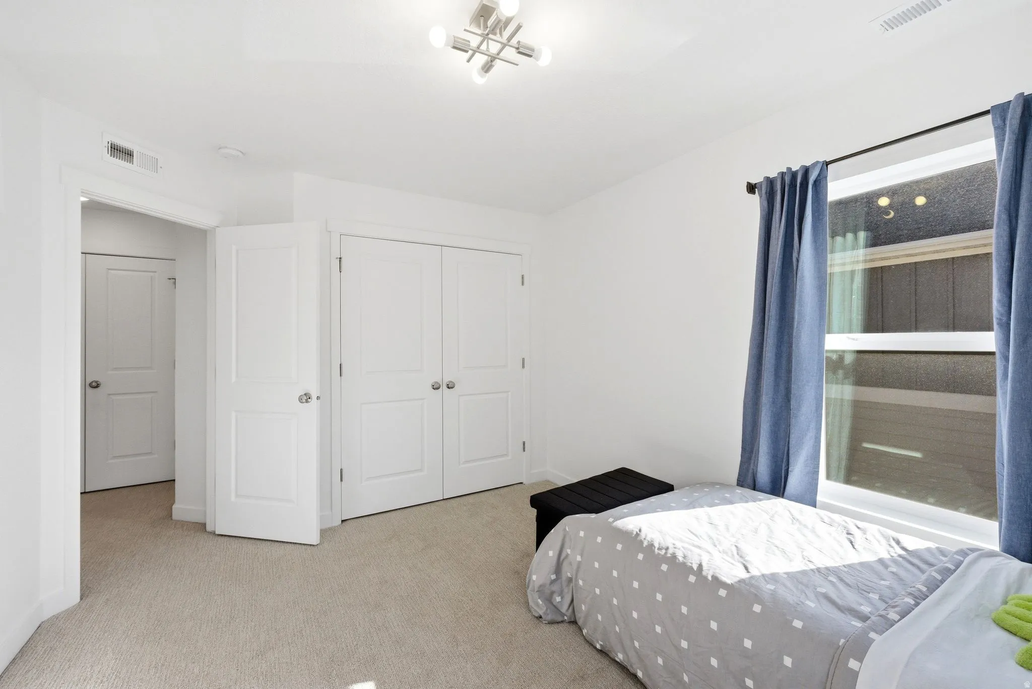 Bedroom featuring light carpet and a closet